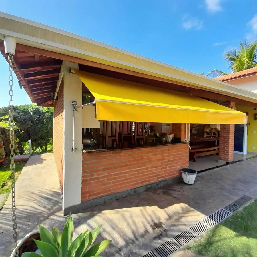 Toldo de Lona instalado em área externa com lona reforçada para proteção contra sol e chuva.